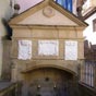 Sur la place jouxtant l'église, se trouve la fontaine des pèlerins, à laquelle on descend par des marches, sous un fronton armorié.